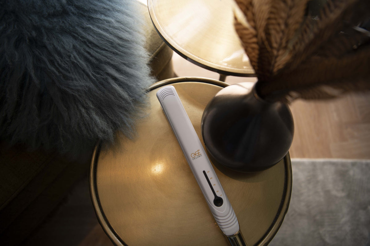 Ogé Exclusive stijltang in wit met goud op een saloncounter